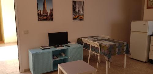 Una cocina con una mesa y un escritorio con televisión. en Viviendas XXIII, en Puerto del Rosario