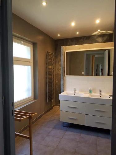 une salle de bain avec un lavabo, un miroir et une fenêtre dans l'établissement Gite de l'eolienne, à Carqueiranne