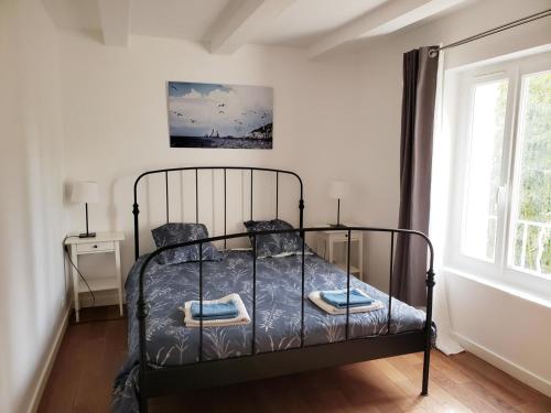 - une chambre avec un lit noir dans une pièce dotée d'une fenêtre dans l'établissement Gite de l'eolienne, à Carqueiranne