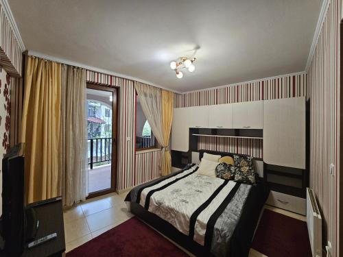 a bedroom with a bed and a window at Частен Апартамент Пампорово Гранд Манастира 2Б5 in Pamporovo