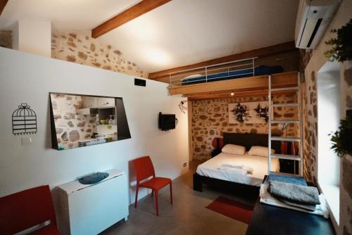 - une chambre avec des lits superposés, un bureau et une chaise dans l'établissement Gite coquet en pierre, à Puget-sur Argens