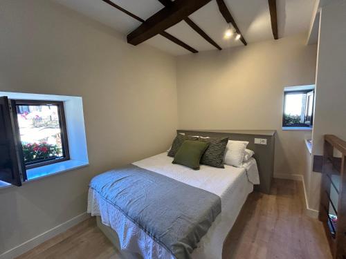 ラス・アレーナス・デ・カブラレスにあるApartamentos San Roqueのベッドと窓のある小さな寝室