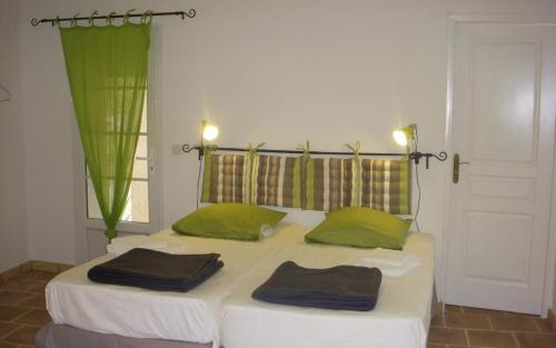 - une chambre avec 2 lits et des oreillers verts dans l'établissement Mourvedre, à La Cadière-dʼAzur