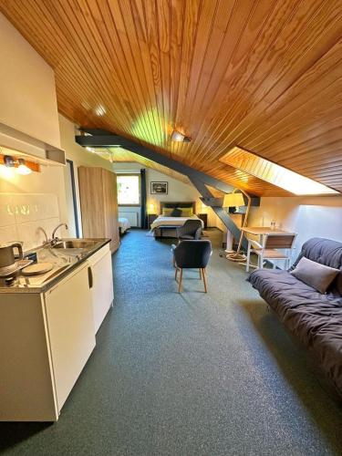 une cuisine et un salon avec un canapé dans l'établissement Aux quatre vents, à Bussière-Galant