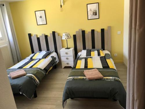 deux lits côte à côte dans une chambre dans l'établissement La cigale jaune a callian, à Callian