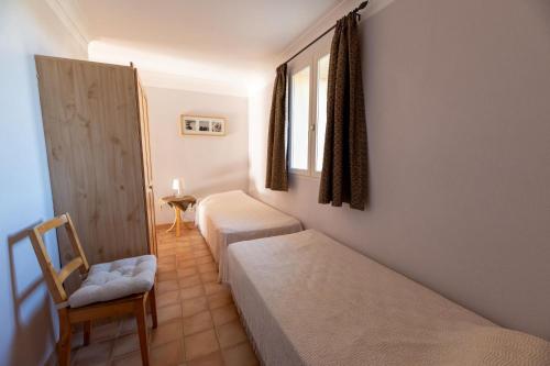 une chambre avec deux lits et une chaise et une fenêtre dans l'établissement Campagne la clape g2365, à Vinon-sur-Verdon