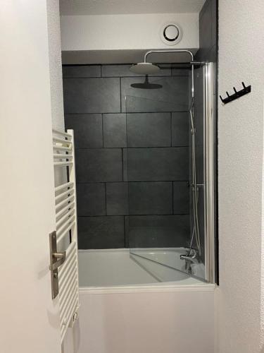 une salle de bain avec une douche avec une porte vitrée dans l'établissement Appartement au pied des pistes, à Saint-François-Longchamp