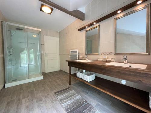 a large bathroom with two sinks and a shower at Hourquet in Ossages