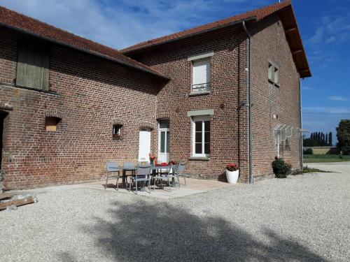 a brick building with a table and chairs at Clair'omer in Yèvres-le-Petit