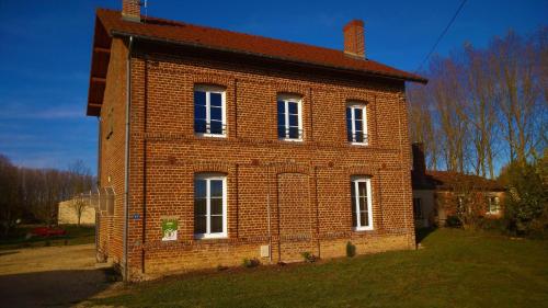 an old brick house with white windows on a yard at Clair'omer in Yèvres-le-Petit