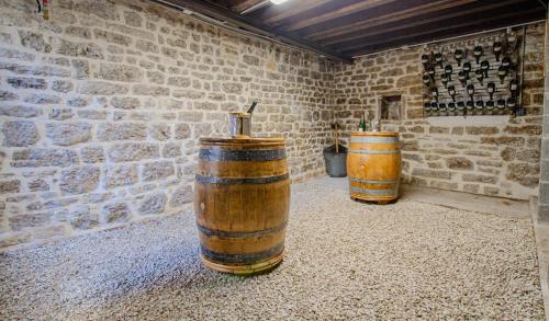 three wooden barrels in a room with a brick wall at Le champenois in Balnot-sur-Laignes