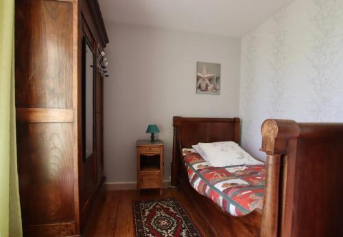 een kleine slaapkamer met een bed en een nachtkastje bij La foret in Aydie
