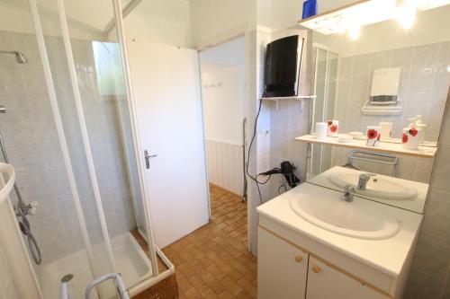 een badkamer met wastafel en douche bij La foret in Aydie