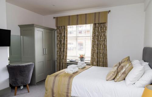a bedroom with a large bed and a window at The Bat and Ball in Canterbury