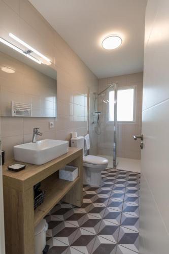 une salle de bain avec un lavabo et des toilettes dans l'établissement callune, à Biscarrosse
