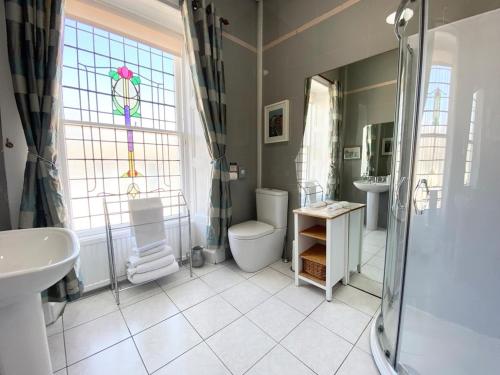a bathroom with a shower and a toilet and a sink at Daviot Guest House in Ayr