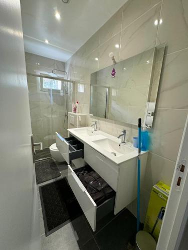 une salle de bain avec un lavabo, des toilettes et un miroir dans l'établissement Bonheur, à Sevran