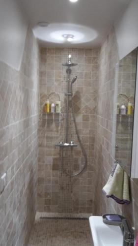 La salle de bains carrelée est pourvue d'une douche et d'un lavabo. dans l'établissement Joli gite les palmiers iii, à La Croix-Valmer