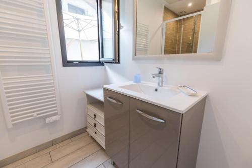 a bathroom with a sink and a mirror at La maison de mon grand-père, appt la landaise du lac in Léon