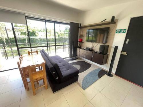 ein Wohnzimmer mit Sofa und Fernseher in der Unterkunft C311Espectacular Apartamento, Condominio Campestre in La Tebaida