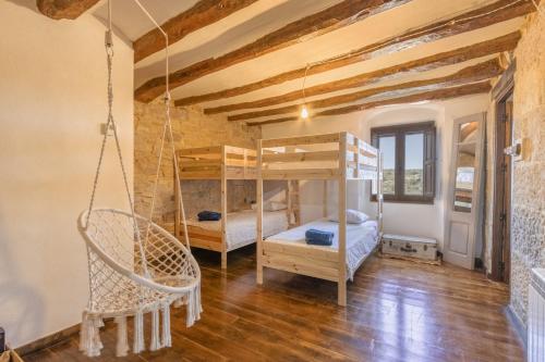 a room with two bunk beds and a swing at Casa Rural Con Spa En La Bodega in Nalech