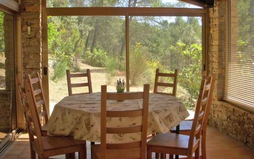 une salle à manger avec une table et des chaises et une fenêtre dans l'établissement Le bastidon des tilleuls, au Beausset
