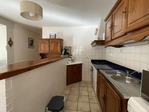 Elle comprend une petite cuisine avec des placards en bois et un évier. dans l'établissement Mendi beheria, à Uhart-Cize