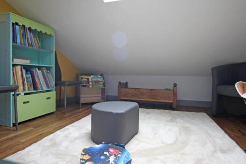 a living room with a chair and a book shelf at Le picatao, les flamanchies in Saint-Mathieu