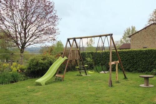 a playground with a slide and a swing at Chez minetou in Saint-Gence