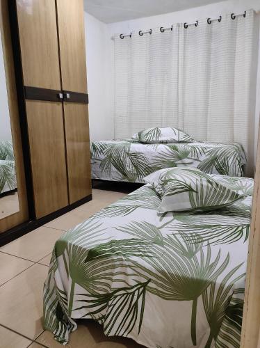 a bedroom with two beds and a closet at Casa Stylo Garanhuns Temporada in Garanhuns