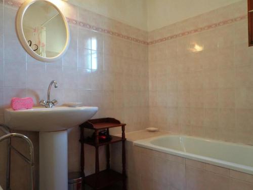 une salle de bain avec un lavabo, une baignoire et un miroir dans l'établissement Les chenes, à Saint-Julien-en-Born