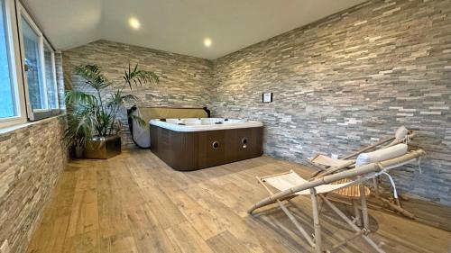 a bathroom with a tub and two chairs at Domaine de juriol - l'annexe in Le Palais-sur-Vienne