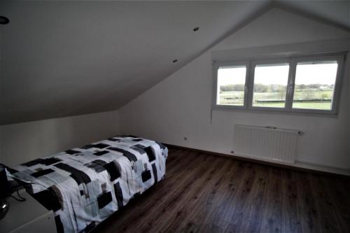 a bedroom with a bed and a window in a attic at Bois de l'age in Saint-Auvent
