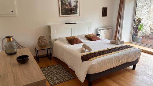 Un dormitorio con una cama grande y una mesa. en Parfum d'Angkor, en Colleville-Montgomery