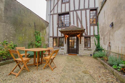a table and chairs in front of a building at L'agapanthe in Bar-sur-Aube