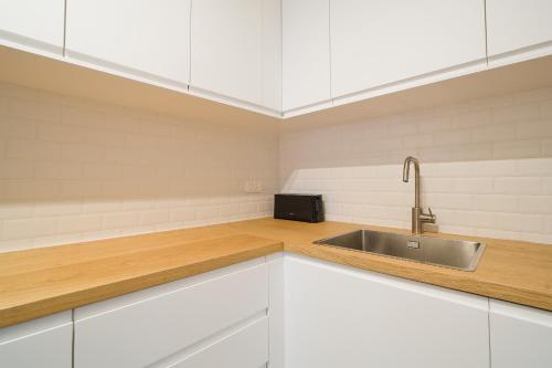 eine Küche mit weißen Schränken und einer Spüle in der Unterkunft Magnifique appartement parisien in Paris