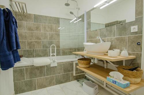 a bathroom with a sink and a mirror and a tub at L'agapanthe in Bar-sur-Aube