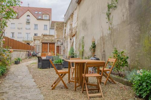 a wooden table and chairs in a courtyard at L'agapanthe in Bar-sur-Aube
