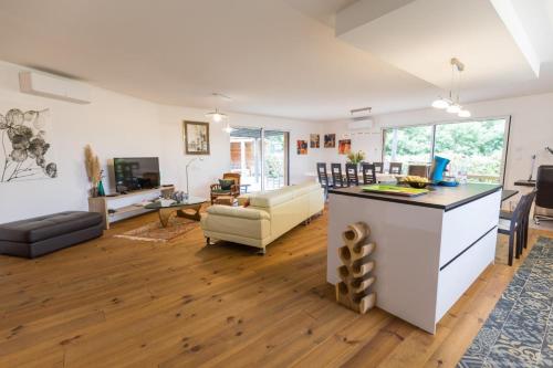 un salon avec une cuisine et un salon avec un canapé dans l'établissement Les oyats, à Biscarrosse