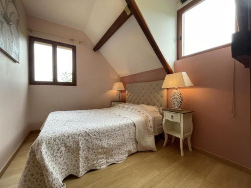 a bedroom with a bed and a table and two windows at Lapouyade in Burosse-Mendousse