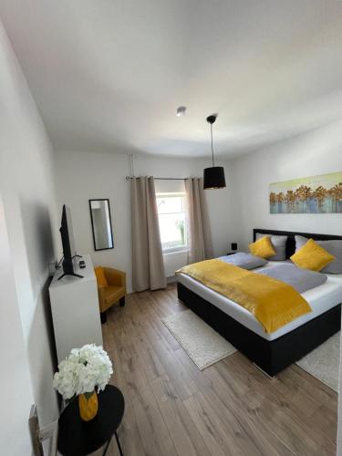 a bedroom with a king sized bed and a television at Bergstadt Apartment Lautenthal ,Modern, Stylisch, Geräumig in Lautenthal