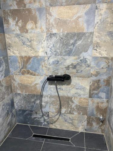 a shower with a blow dryer on a stone wall at Sarajevo Deluxe penthouse and pool in Sarajevo