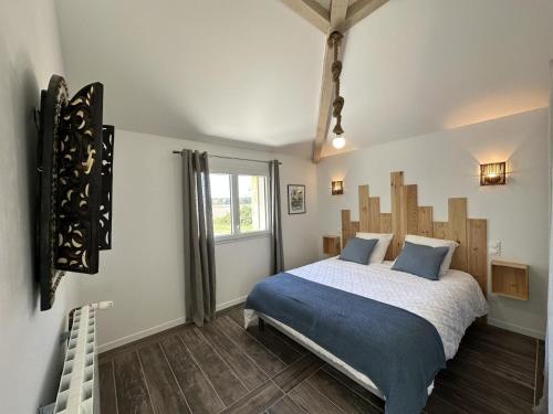 a bedroom with a large bed with blue pillows at La maison poulet in Soustons
