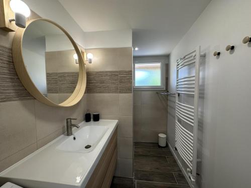 a bathroom with a sink and a mirror at La maison poulet in Soustons