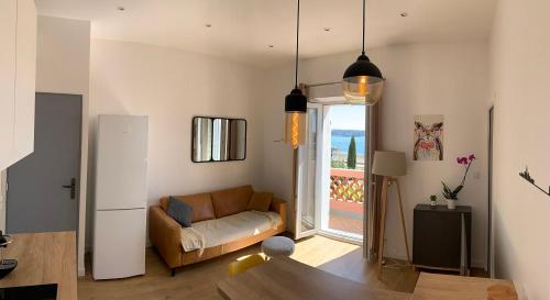 un salon avec un canapé et une fenêtre dans l'établissement Appartement vue mer, à Bandol