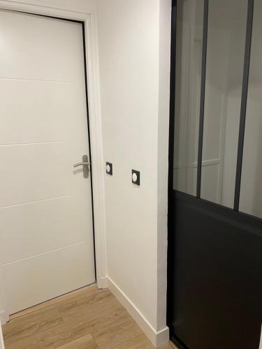 une pièce avec une porte blanche et un miroir dans l'établissement Appartement centre Ville Rambouillet 4 personnes, à Rambouillet