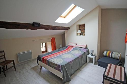 a bedroom with a bed and a chair at Le chat qui peche in Rilhac-Rancon