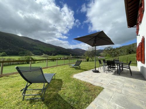 a patio with a table and chairs and an umbrella at Lexorua in Ibarrolle
