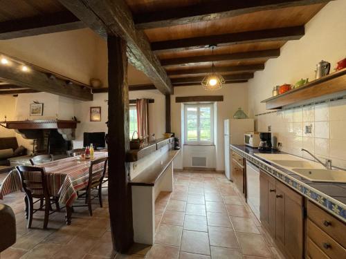 a large kitchen with wooden ceilings and a table at Lexorua in Ibarrolle