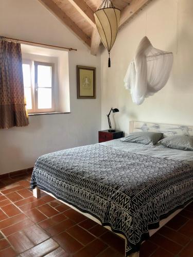 a bedroom with a bed and a window at Casa Swagatam in Aljezur